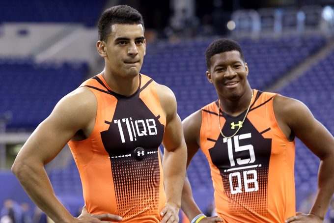 Oregon quarterback Marcus Mariota (11) and Florida State quarterback Jameis Winston (15) wait to run a drill at the NFL football scouting combine in Indianapolis, Saturday, Feb. 21, 2015. (AP Photo/David J. Phillip)