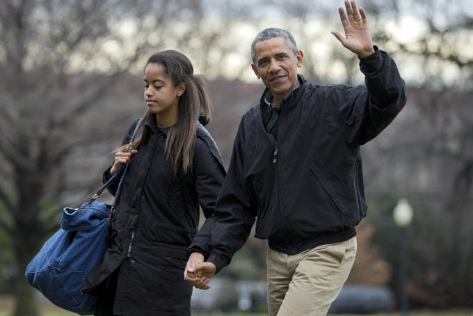 In this Jan. 4, 2015 file photo, President Barack Obama, with his daughter Malia Obama, waves as they arrive at the White House in Washington. (AP Photo/Manuel Balce Ceneta, File)