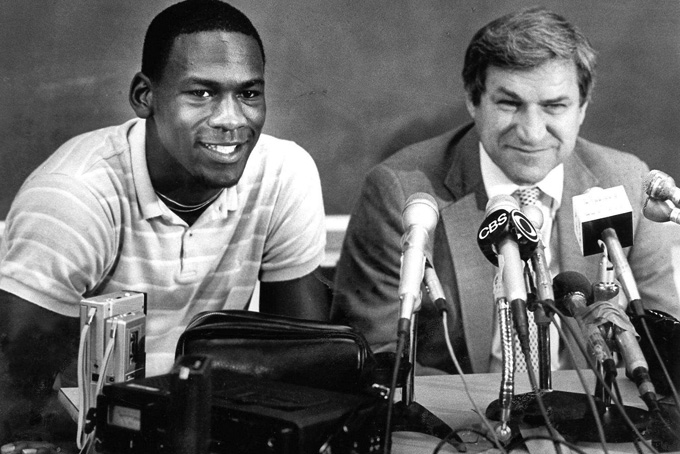 in this May 5, 1984 file photo, North Carolina guard Michael Jordan, left, and Tar Heels coach Dean Smith are shown at a news conference in Chapel Hill, N.C., where Jordan announced he would forfeit his final year of college eligibility to turn pro. Smith, the North Carolina basketball coaching great who won two national championships, died "peacefully" at his home Saturday night, Feb. 7, 2015, the school said in a statement Sunday from Smith's family. He was 83. (AP Photo, File)
