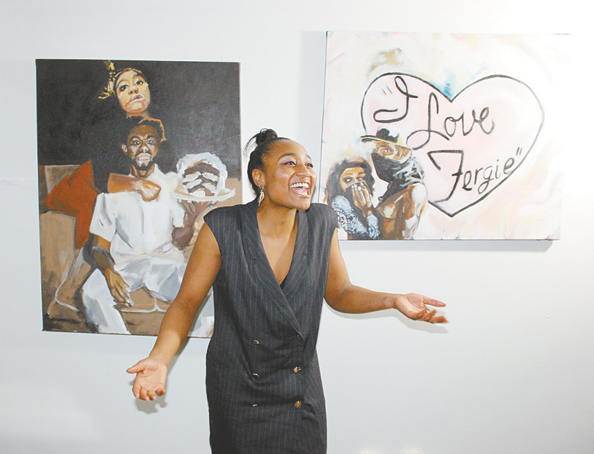 ENJOYING HER WORK—Naomi Walker laughing and talks with friends who came out to support her and her art. Hanging behind her are two pieces of her work. (Photos by J.L.Martello.)