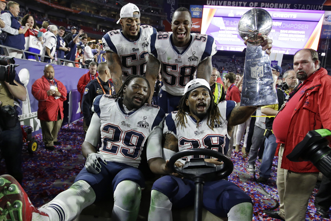 New England Patriots's LeGarrette Blount (29), Brandon Bolden (38), Jonathan Casillas and Darius Fleming (58) celebrate with the Vince Lombardi Trophy aft the NFL Super Bowl XLIX football game against the Seattle Seahawks Sunday, Feb. 1, 2015, in Glendale, Ariz. The Patriots won 28-24. (AP Photo/Michael Conroy)