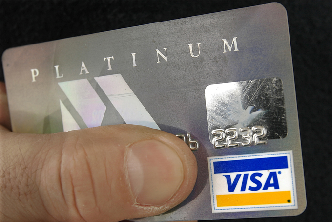 In this Feb. 25, 2008 file photo, a cardholder poses with his Visa credit card, in Springfield, Ill. In an effort to combat credit card fraud, the payment processor Visa on Thursday, Feb. 12, 2015 said it will be rolling out a product next month that will track credit card users on their smart phones. (AP Photo/Seth Perlman, File)