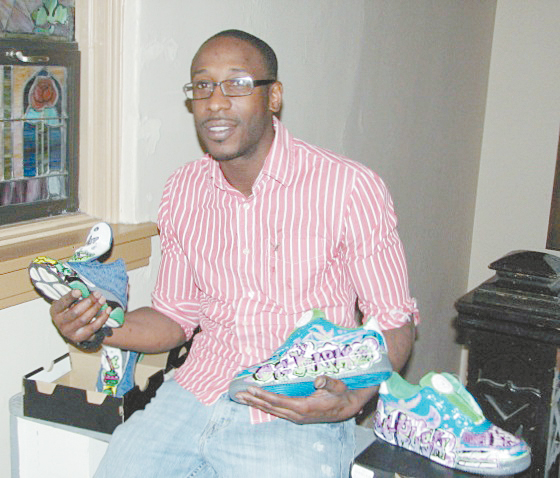 WHAT A TALENT—James Young, a MBI participant shows his creative work on shoes he has on the market.    