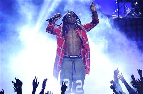In this June 29, 2014 file photo, Lil\' Wayne performs at the BET Awards at the Nokia Theatre in Los Angeles. Police have responded to a report of 4 people shot at the Miami Beach home of rapper Lil Wayne. Miami Beach Det. Vivian Thayer says police units responded Wednesday, March 11, 2015, after someone called to say four people had been shot at the waterfront home. (Photo by Chris Pizzello/Invision/AP, File)