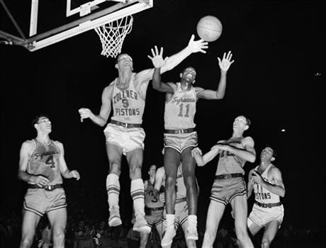 FILE - In this April 1955 file photo, Fort Wayne\'s Mel Hutchins (9) and Syracuse\'s Earl Lloyd (11) reach for the ball during an NBA basketball game in Indianapolis. Lloyd, the first black player in NBA history, died Thursday, Feb. 26, 2015. He was 86. Lloyd\'s alma mater, West Virginia State, confirmed the death. It did not provide details. Lloyd made his NBA debut in 1950 for the Washington Capitals, just before fellow black players Sweetwater Clifton and Chuck Cooper played their first games. (AP Photo/File)