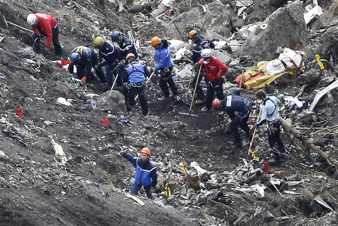 Rescue workers work on debris of the Germanwings jet at the crash site near Seyne-les-Alpes, France, Thursday, March 26, 2015. (AP Photo/Laurent Cipriani)