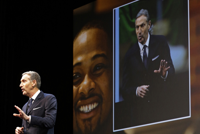 Starbucks Corp. CEO Howard Schultz speaks Wednesday, March 18, 2015 in front of an image of a barista at the coffee company's annual shareholders meeting in Seattle. (AP Photo/Ted S. Warren)