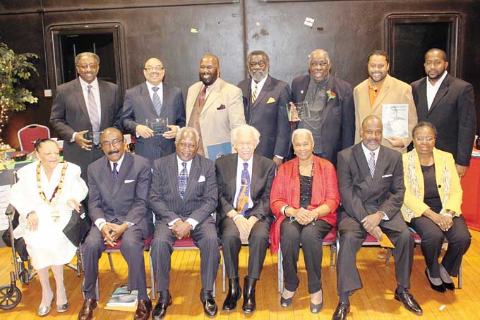 COMMUNITY LEGENDS CELEBRATED—Classic Events!, headed by Ralph Watson, hosted its 4th Annual Black History Celebration Dinner at Hosanna House, located at 807 Wallace Ave. in Wilkinsburg. The theme was “Legends.” Several of the community’s legends were honored for their work. Pictured above are honorees with Ralph Watson, seated second from right. Seated, from left: Honorees Frances Ford Wilson, Dr. Herman Reid Jr., Roger Humphries, Judge Warren Watson, Brenda Frazier, Watson and Renee Frazier.  Standing, from left: J.T. Thomas, Chris Moore, Bill Neal, Rev. Dr. Johnnie Monroe, Bill Robinson, and Morris Turner Jr. and Derrick Turner, who accepted an award on behalf of their father, the late Dr. Morris Turner Sr. (Photo by J.L. Martello)