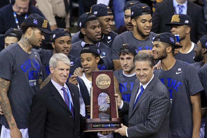 FILE - In this March 28, 2015, file photo, Kentucky coach John Calipari, right, holds the regional championship trophy after the team's 68-66 win over Notre Dame in a college basketball game in the NCAA men's tournament regional finals in Cleveland. Quinn Buckner and his 1975-76 Indiana teammates don’t plan on celebrating if their reign as college basketball’s last undefeated team continues. Instead, the Hoosiers have waited 39 years to welcome another undefeated national champion. (AP Photo/Aaron Josefczyk, File)