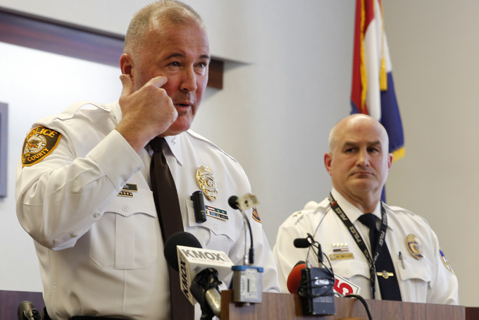 St. Louis County police Chief Jon Belmar, left, describes where one officer was shot on his face as Webster Groves police Captain Mike Nelson listens during a news conference Thursday, March 12, 2015, in  Clayton, Mo. Belmar spoke about the two officers who were shot, one from the St. Louis County police department and one from Webster Groves, in front of the Ferguson Police Department early Thursday as demonstrators gathered. (AP Photo/Jeff Roberson)