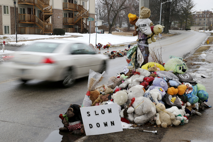 A car passes a memorial for Michael Brown, who was shot and killed by Ferguson, Mo., Police Officer Darren Wilson last summer, Tuesday, March 3, 2015, in Ferguson. A Justice Department investigation found sweeping patterns of racial bias within the Ferguson police department, with officers routinely discriminating against blacks by using excessive force, issuing petty citations and making baseless traffic stops, according to law enforcement officials familiar with the report. (AP Photo/Charles Rex Arbogast)