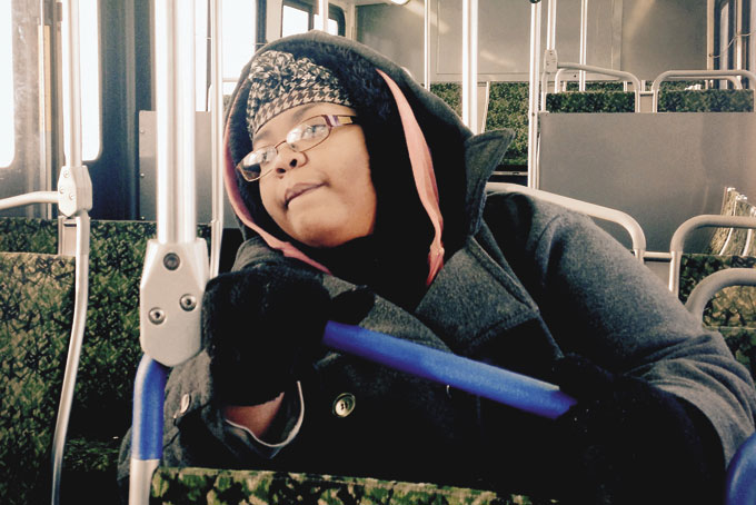 2-HOUR COMMUTE—In a photo from Feb. 12, 2015, Alison Norris, 26, sits on a public bus in Detroit. Norris catches at least two buses during a 2-hour, one-way commute from Detroit to her restaurant hostess job in the city’s northern suburbs. (AP Photo/Corey Williams)
