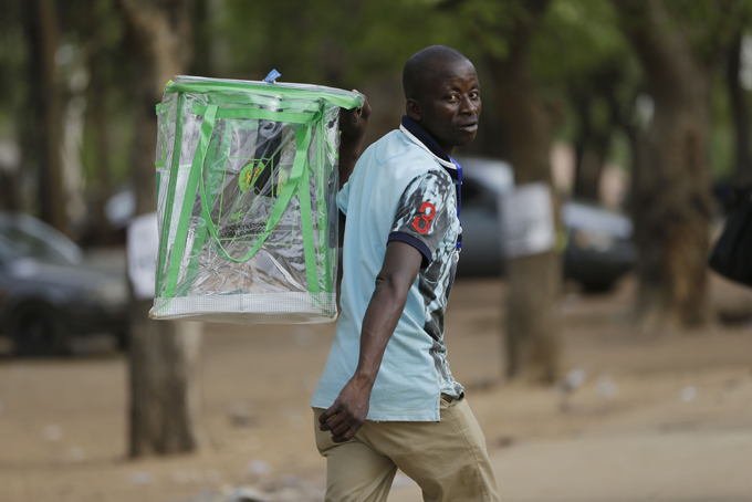 An election official walks away with an empty ballot box at the end of votes count in one of the polling stations in Yola, Nigeria Saturday, March 28, 2015. Nigerians went to the polls Saturday in presidential elections which analysts say will be the most tightly contested in the history of Africa's richest nation and its largest democracy. (AP Photo/Sunday Alamba)