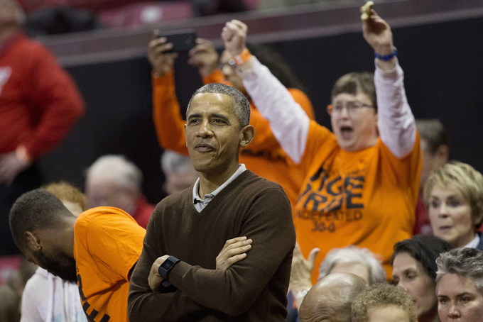 President Barack Obama, center, watches the player's introductions of the Princeton vs Green Bay women's college basketball game in the first round of the NCAA tournament in College Park, Md., Saturday, March 21, 2015. Obama's niece Leslie Robinson, plays for Princeton.(AP Photo/Pablo Martinez Monsivais)