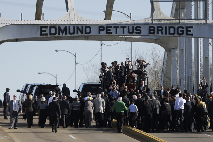 President Barack Obama, first lady Michelle Obama, Malia and Sasha as well as members of Congress and civil rights leaders make a symbolic walk across the Edmund Pettus Bridge, Saturday, March 7, 2015, in Selma, Ala. This weekend marks the 50th anniversary of "Bloody Sunday,' a civil rights march in which protestors were beaten, trampled and tear-gassed by police at the Edmund Pettus Bridge, in Selma. (AP Photo/Gerald Herbert)