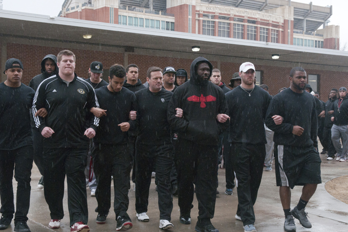 The University of Oklahoma football team and coaches line up wearing all black in the Everest Training Center in protest of the Sigma Alpha Epsilon fraternity at the University of Oklahoma on Monday, March. 9, 2015. The Sigma Alpha Epsilon fraternity has been banned from campus after several members tof the fraternity took part in a racist chant caught on video. (AP Photo/Tulsa World, Nick Oxford) 