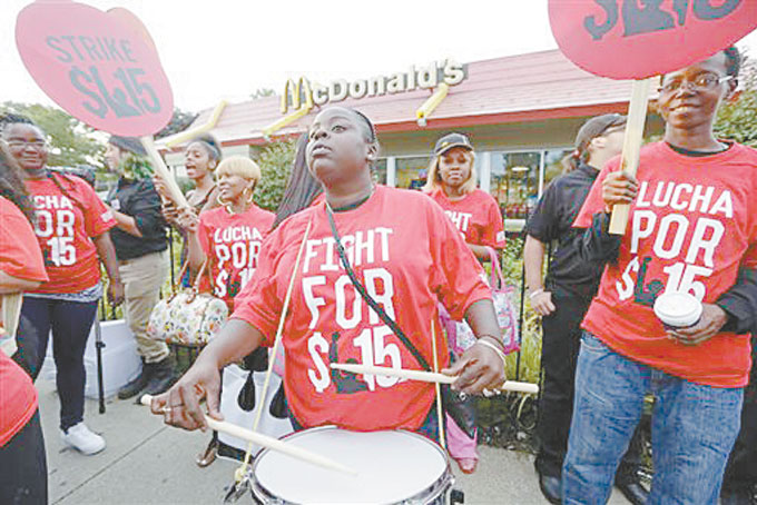 PROTEST—In this Sept. 4, 2014 file photo, Carmalita Johnson drums as protesters participate in a rally outside a McDonald’s on Chicago’s south side as labor organizers escalate their campaign to unionize the industry’s workers. Franchise owners wonder whether they’ll lose autonomy as a result of hearings into about 80 charges against McDonald’s and some of its franchisees. (AP Photo/M. Spencer Green, File)