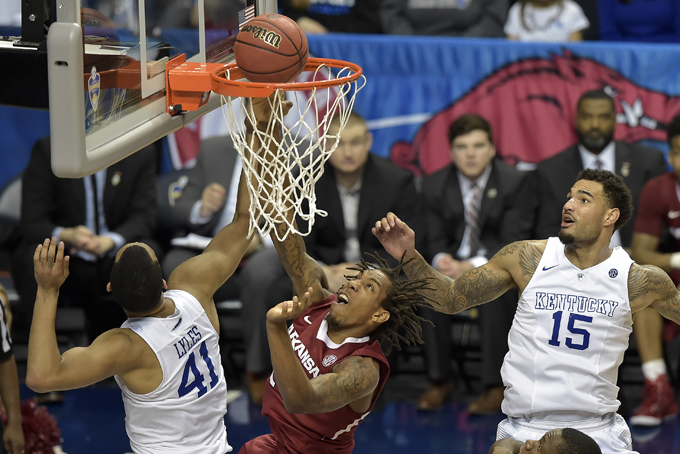 Arkansas guard Michael Qualls (24) shoots as Kentucky forward Trey Lyles (41) and Kentucky forward Willie Cauley-Stein (15) look on during the second half of the NCAA college basketball Southeastern Conference tournament championship game, Sunday, March 15, 2015, in Nashville, Tenn. Kentucky won 78-63. (AP Photo/Mike Stewart)