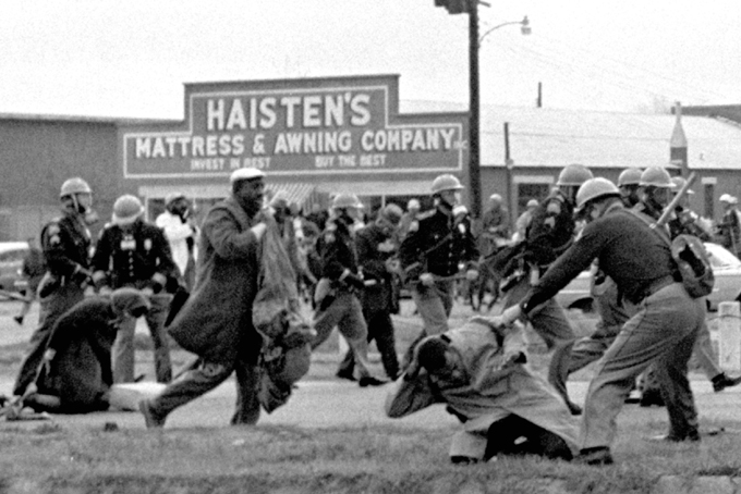 In this March 7, 1965 file photo, state troopers use clubs against participants of a civil rights voting march in Selma, Ala. At foreground right, John Lewis, chairman of the Student Nonviolent Coordinating Committee, is beaten by a state trooper. The day, which became known as "Bloody Sunday," is widely credited for galvanizing the nation's leaders and ultimately yielded passage of the Voting Rights Act of 1965. (AP Photo/File)