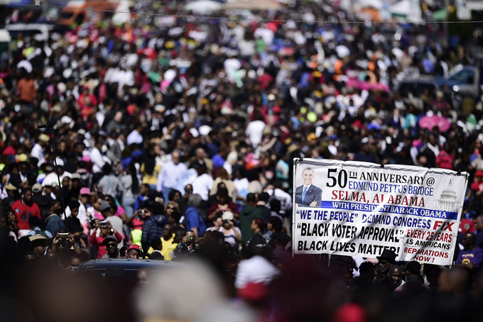 Crowds gather near the Edmund Pettus Bridge, Sunday, March 8, 2015, in Selma, Ala. This weekend marks the 50th anniversary of "Bloody Sunday,' a civil rights march in which protestors were beaten, trampled and tear-gassed by police at the Edmund Pettus Bridge, in Selma. (AP Photo/Bill Frakes)