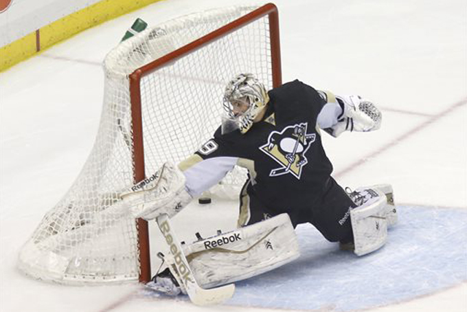 The puck gets past Pittsburgh Penguins goalie Marc-Andre Fleury (29) for a goal on a shot by Columbus Blue Jackets' James Wisniewski in the first period of an NHL hockey game, Sunday, March 1, 2015, in Pittsburgh. (AP Photo/Keith Srakocic)