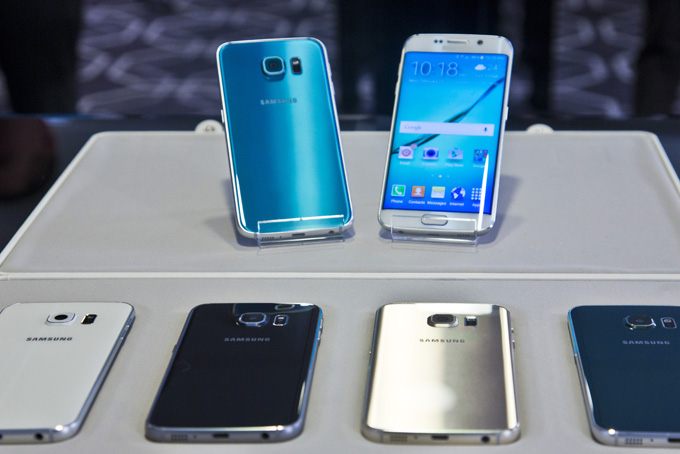 Two new Samsung phones, Galaxy S6, top left, and Galaxy S6 Edge, to right, are on display with choice of color selections at a special press preview, Monday, Feb. 23, 2015, in New York. Samsung officially unveiled the stylish new phones on Sunday, March 1, 2015, the eve of this week's Mobile World Congress wireless show in Barcelona, Spain. (AP Photo/Bebeto Matthews)