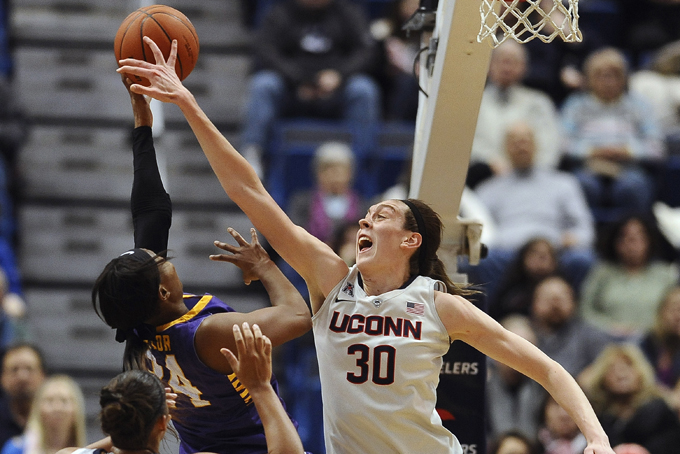 In this Jan. 28, 2015, file photo, Connecticut’s Breanna Stewart, right, blocks a shot attempt by East Carolina’s I'Tiana Taylor as Connecticut's Kaleena Mosqueda-Lewis, left, defends during the first half of an NCAA college basketball game in Hartford, Conn. Stewart was selected to the AP All-America team, Tuesday, March 31, 2015. (AP Photo/Jessica Hill, File)