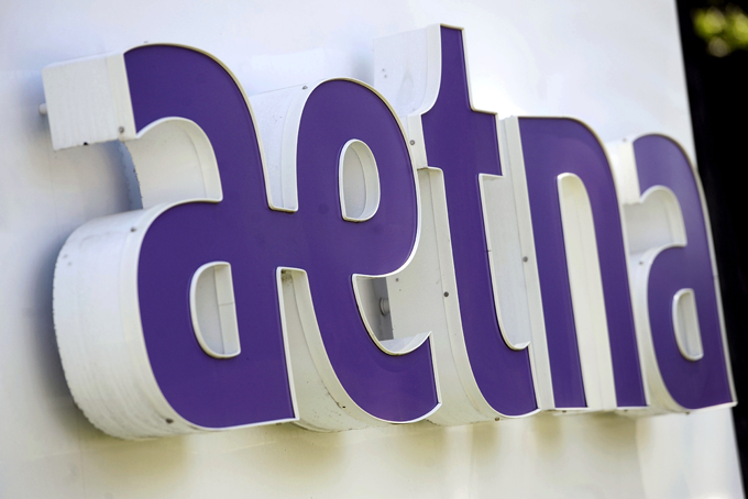 This Tuesday, Aug. 19, 2014 file photo shows signage in front of Aetna Inc.'s headquarters in in Hartford, Conn. Aetna is urging gay customers to "be proud" — and consider buying its coverage — as part of a new, narrow focus to selling health insurance in a business where the individual's buying decision matters more than it used to. (AP Photo/Jessica Hill, File)