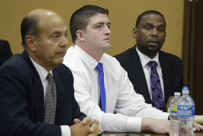 Cleveland police Officer Michael Brelo, center, listens with his attorneys to opening arguments in court, Monday, April 6, 2015, in Cleveland. Brelo, 31, went on trial Monday on two counts of voluntary manslaughter in the November 2012 deaths of Timothy Russell, 43, and Malissa Williams, 30, after a high-speed chase. (AP Photo/Tony Dejak, Pool)