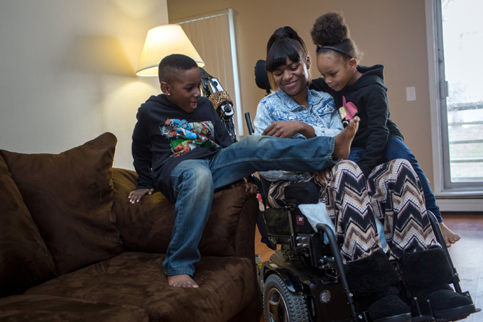 Tanesha Johnson, center, and her 6-year-old son Tavaris and 4-year-old daughter Tanaya laughed and tickled one another Friday, April 10, 2015, in their Brooklyn Center, Minn., apartment. (Jennifer Simonson/Minnesota Public Radio via AP)