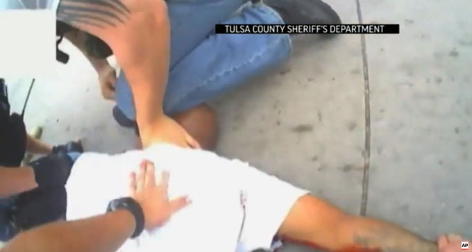 In this screen shot from April 2, 2015 video provided by the Tulsa County Sheriff's Office, police restrain 44-year-old Eric Harris after he was chased down and tackled by a Tulsa County Deputy, and then shot by a reserve sheriff's deputy while in custody, in Tulsa, Okla.  (AP Photo/Tulsa County Sheriff's Office)