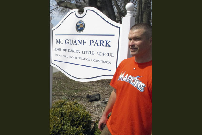 In this April 6, 2015 photo, Christopher Stefanoni poses at the Darien Little League park in Darien, Conn., Stefanoni is suing the Darien Little League in federal court, saying league officials demoted his 9-year-old son to a lower-level team as retribution for his affordable housing proposal. Lawyers for the Little League deny the allegations. (AP Photo/Dave Collins)