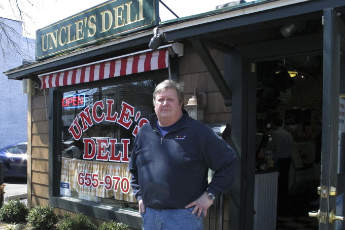 In this Monday, April 6, 2015, photo, Rob Williamson stands outside his deli in Darien, Conn. Williamson doesn't believe the town is being discriminatory in rejecting affordable housing applications. "The town's small, very tight knit," the resident of nearby Stamford said. "That doesn't mean we want to keep anyone out. It's a small, little New England town and I think they want to keep it that way."       (AP Photo/Dave Collins)