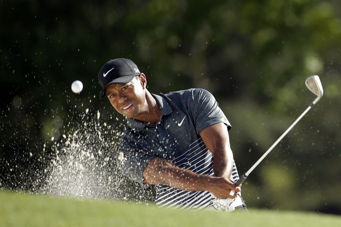 Tiger Woods hits out of a bunker on the 18th hole during the third round of the Masters golf tournament Saturday, April 11, 2015, in Augusta, Ga. (AP Photo/Chris Carlson)