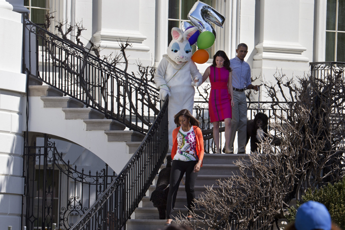 First lady Michelle Obama, left, along with the two presidential pet dogs Sunny and Bo, President Obama, right, the Easter Bunny, and an aide, walk down the stairs at the White House to take part in the White House Easter Egg Roll on the South Lawn of White House in Washington, Monday, April 6, 2015. Thousands of children gathered at the White House for the annual Easter Egg Roll. This year's event features live music, cooking stations, storytelling, and of course, some Easter egg roll. (AP Photo/Jacquelyn Martin)