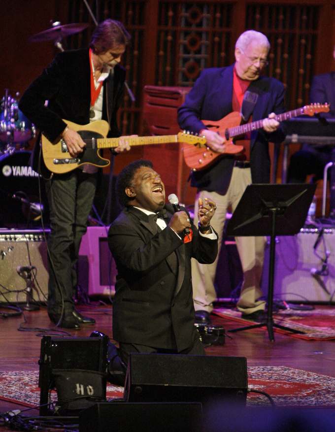 In this Oct. 28, 2008 file photo, Percy Sledge kneels as he performs "When a Man Loves a Woman" along with the Muscle Shoals Rhythm Section at the Musicians Hall of Fame awards show in Nashville, Tenn. Sledge, who recorded the classic 1966 soul ballad "When a Man Loves a Woman," died, Tuesday April 14, 2015. He was 74. (AP Photo/Mark Humphrey, File)