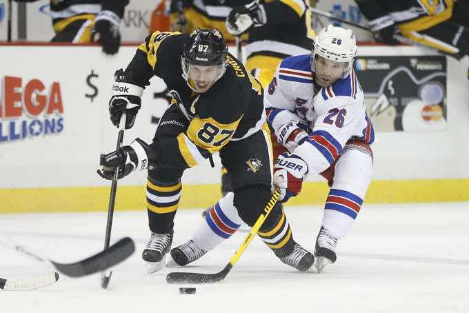 In this Nov. 15, 2014, file photo, Pittsburgh Penguins' Sidney Crosby (87) gets the puck past New York Rangers' Martin St. Louis (26) in the second period of an NHL hockey game in Pittsburgh. Sidney Crosby and the Pittsburgh Penguins are hitting Broadway to face the Blueshirts in the NHL playoffs for the second straight year. (AP Photo/Keith Srakocic, File)