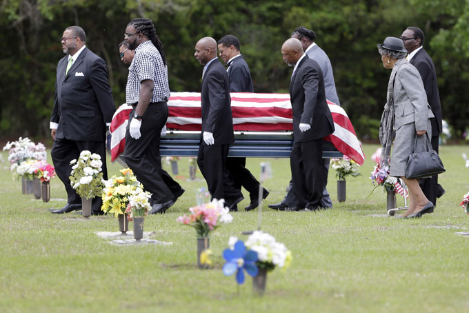 Pallbearers walk Walter Scott's casket to the gravesite for his burial service in Charleston, S.C. on Saturday, April 11, 2015. Scott was fatally shot by a North Charleston, S.C., police officer a week earlier after a traffic stop. Officer Michael Slager has been charged with murder.