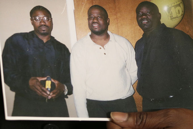 In this April 8, 2015 photo, Anthony Scott holds an undated photo that shows himself, center, and his brothers Walter Scott, left, and Rodney Scott, right, as he talks about Walter at his home near North Charleston, S.C. Walter Scott was killed by a North Charleston police officer after a traffic stop on Saturday, April 4, 2015. The officer, Michael Thomas Slager, has been fired and charged with murder. (AP Photo/Scott Family)
