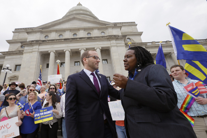 Chad Griffiin, president of the Human Rights Campaign, center, speaks with Kendra Johnson of the Arkansas chapter of the organization at the Arkansas state Capitol in Little Rock, Ark., Wednesday, April 1, 2015.  Arkansas Gov. Asa Hutchinson on Wednesday called for changes to a religious objection measure facing a backlash from businesses and gay rights groups, saying it wasn't intended to sanction discrimination based on sexual orientation. (AP Photo/Danny Johnston)