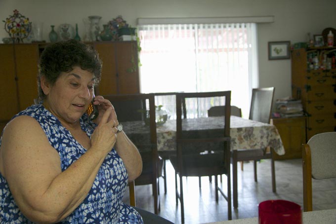 In this photo taken April 3, 2015, Jeri Vargas takes a phone call at her mother's home in the Sherman Oaks area of Los Angeles. Jeri Vargas put her elderly mother on the “Do Not Call” list years ago. So why is the 88-year-old woman with Alzheimer’s disease still getting several recorded phone calls a day pitching her everything from vacation cruises to medical alert devices and fire extinguishers? (AP Photo/Damian Dovarganes)