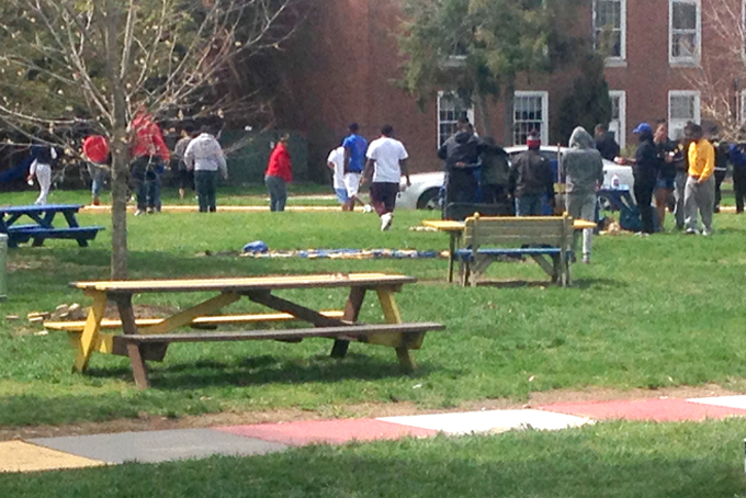 Students at Delaware State University disperse Sunday morning, April 19, 2015,  after cleaning up the area where three people were shot and injured Saturday during a university-sanctioned cookout on campus in Dover, Del. Authorities are searching for the shooter. DSU President Harry L. Williams said students have been told to stay inside their dormitories. Non-students were asked to leave campus. A second shooting occurred early Sunday at an apartment complex just off campus, but no one was injured.  (AP Photo/Randall Chase)