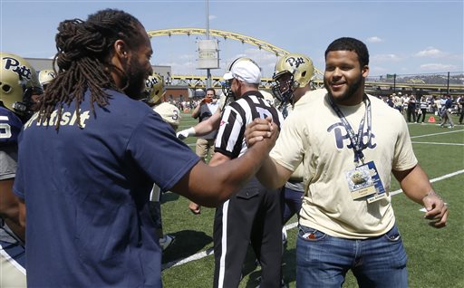 Pittsburgh alumni, Phoenix Cardinals wide receiver Larry Fitzgerald, left, and St. Louis Rams defensive tackle Aaron Donald, shake hands before the coin toss of their former NCAA football teams' Blue Gold spring football game, Saturday, April 18, 2015 in Pittsburgh. Fitzgerald was the honorary coach for the Blue team and Donald the honorary coach for the Gold. (AP Photo/Keith Srakocic)