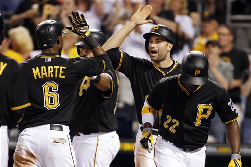 Pittsburgh Pirates' Starling Marte (6) celebrates with Neil Walker, center, as he crosses the plate after hitting a three-run home run off Milwaukee Brewers starting pitcher Kyle Lohse in the fifth inning of a baseball game in Pittsburgh, Saturday, April 18, 2015. (AP Photo/Gene J. Puskar)