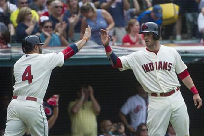 Cleveland Indians' Mike Aviles is greeted Yan Gomes after Aviles scoring against the Cincinnati Reds during the sixth inning of a baseball game against the Cleveland Indians, in Cleveland, Sunday, May 24, 2015. (AP Photo/Phil Long)