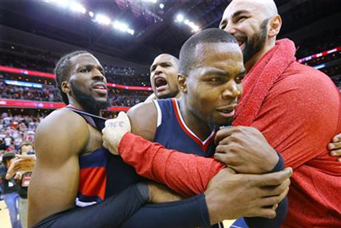 Atlanta Hawks' DeMarre Carroll, Al Horford, Paul Millsap and Pero Antic, from left, celebrate after the Hawks defeated the Washington Wizards 94-91 in Game 6 of an NBA basketball playoffs second-round series, Friday, May 15, 2015, in Washington. The win sent the Hawks to the Eastern Conference finals. (Curtis Compton/Atlanta Journal-Constitution via AP)