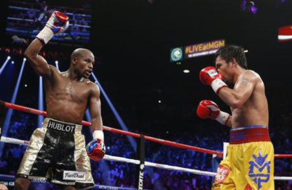 Floyd Mayweather Jr., left, celebrates during his welterweight title fight against Manny Pacquiao, from the Philippines, on Saturday, May 2, 2015 in Las Vegas. (AP Photo/John Locher)