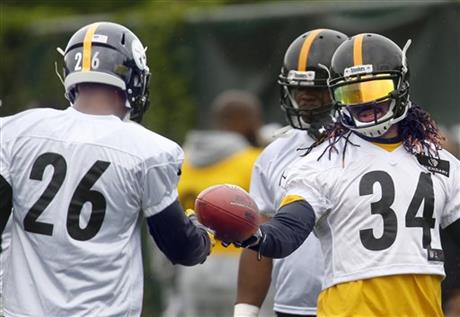 In this photo taken Tuesday, May 26, 2015. Pittsburgh Steelers running back DeAngelo Williams, right, gives the ball to fellow running back Le'Veon Bell during an NFL football organized team activity in Pittsburgh. Williams is expected to start the first three games of the season, as Bell serves a suspension. (AP Photo/Keith Srakocic)
