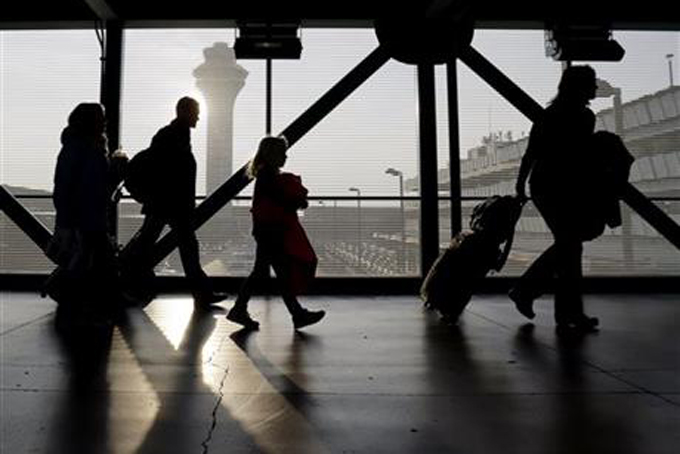 In this Dec. 1, 2013 file photo, travelers walk through terminal 3 at O'Hare International airport in Chicago. On top of the bag fees and other charges, families traveling this summer may have to pay extra just to sit next to one another. (AP Photo/Nam Y. Huh, File)