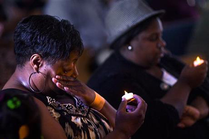 Jackie Pillow wipes a tear from her eye during a vigil to mourn the lives lost at the shooting in Charleston, S.C., Thursday, June 18, 2015, at Taylor Chapel AME Church in Bowling Green, Ky. Dylann Storm Roof, 21, was arrested Thursday in the slayings of several people, including the pastor at a prayer meeting inside a historic black church. (Austin Anthony/Daily News via AP)